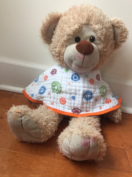teddy bear wearing aden+ anais burp cloth bib as bib