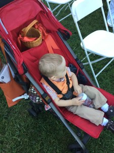 Joovy Groove Ultralight umbrella stroller with toddler riding and loaded down with bags