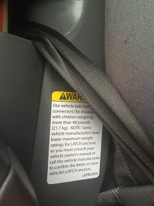 Warning label about LATCH anchor weight limits attached to Graco Nautilus 3 in 1 booster seat