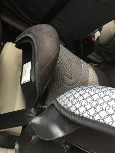 Side of a booster belt positioning car seat with manfucaturer's lable shown attached to bottom