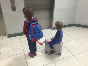 Child with backpack suitcase from Yodo Kids pulling toddler on JetKids bed box suitcase