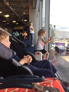 Five year old sitting at window at the airport gate on a JetKids BedBox