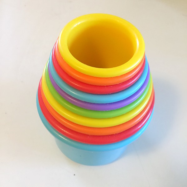 Ten stacking cups in rainbow colors shown nested