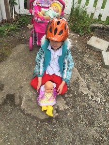 Child playing with dolls outdoors