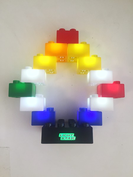 Light Stax illuminated blocks shown lit up and mixed with Lego Duplo block on top