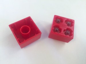 Undersides of a Lego Duplo block shown next to a Light Stac blockt