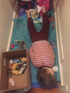 Six year old passed out on rug in hall among scattered toys