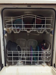 Dishwasher shown open partially filled with dirty dishes