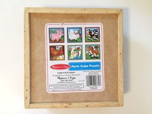 Melissa and Doug wooden cube puzzle storage tray backside showing all six completed puzzle images