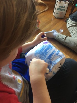 Preschooler coloring on Doodlemals stuffed animal with crayola markers