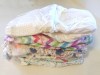 a stack of disposable diapers from Honest company and huggies brands