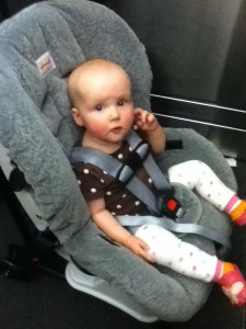 Infant riding in car seat wearing baby leg warmers