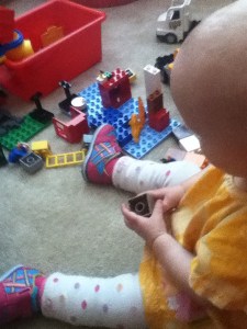 Infant playing with toys while wearing baby leg warmers