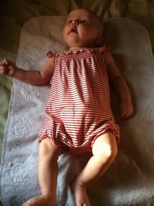 Infant lying on bed on top of changing pad