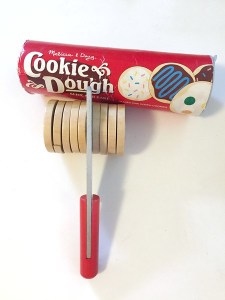 Melissa Doug wooden cookie slice bake set knife slicing into roll of cookies with canister behind