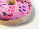 Scented plush donut pillow with pink frosting and rainbow sprinkles