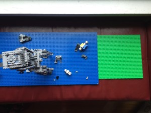 Lego brand square green base plate next to blue long double sided base plate