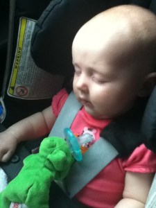 Infant sleeping in car seat on airplane with wubbanub soothie pacifier resting on chest