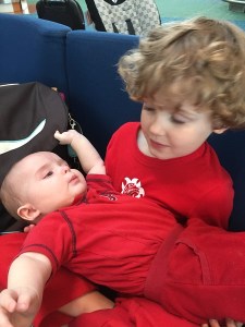 Child holding baby wearing red shirts