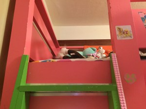 Mayka toy block tape attached along green ladder to pink bunk bed