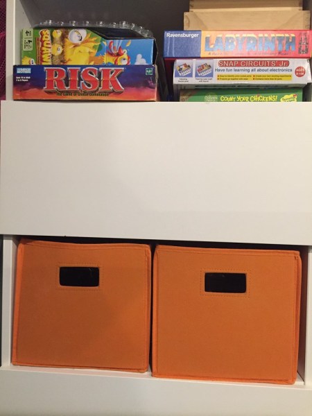 Storage bins in orange on Besta storage shelf