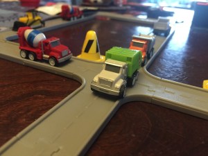 Driven pocket series green tiny dump truck on gray connecting road pieces