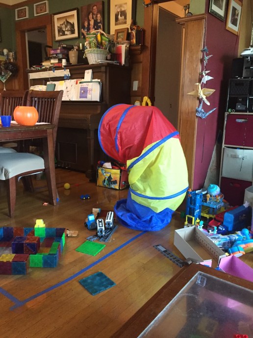 Child standing hidden inside kids pop up tunnel