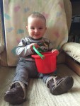 toddler sitting in rocking chair with red spielstabil bucket