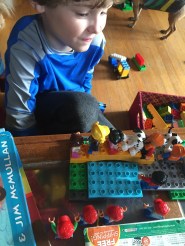 Seven year old playing with Duplo people figurines