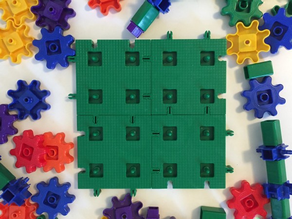 Four green gear base plates connected together