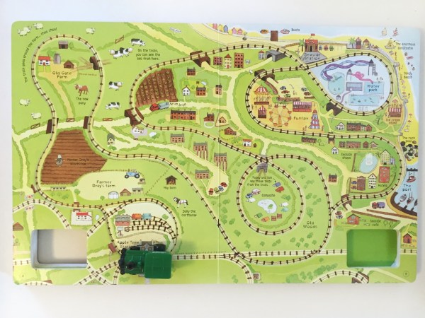 Train on embedded track of page spread from wind up train book by Usborne