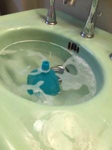 Funnel partially submerged in soapy water in bathroom sink