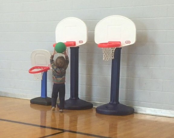 Toddler scoring in Little Tikes basketball hoops