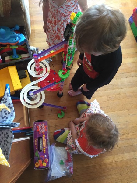 Kids gathered around marble run