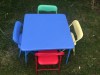 Kids blue folding table set up with folding chairs in blue yellow green and red