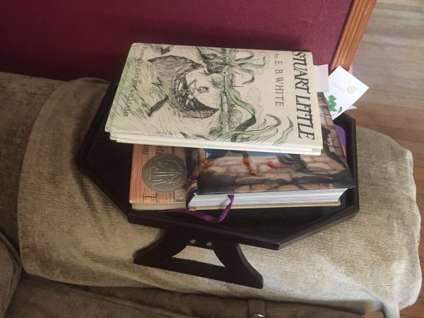 Book stacked on sofa arm clip table