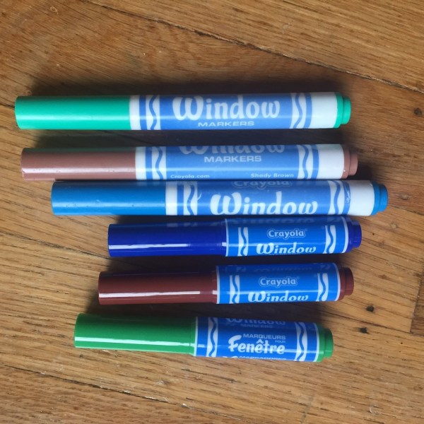 Mini and regular window markers from Crayola shown side by side on wooden floor