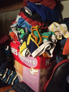 Five year old clothes overflowing Huggies disposable diaper box