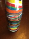 Colored sand layered in empty clear wine bottle by three year old
