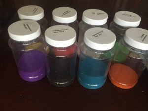 Colored sand 22 oz jars mostly empty with sand remaining at bottom