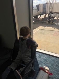 Child eating burrito at airport window waiting to board