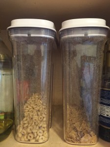 OXO Good Grips medium airtight POP cereal dispensers side by side in cabinet with cereal partially filled