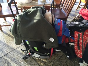 Car seat attached to travel cart hauling other luggage