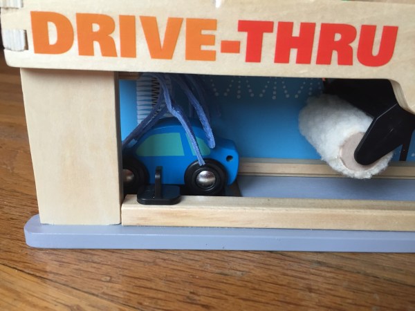 Melissa and Doug Service Station Parking Garage Play set with blue car going through car wash brushes