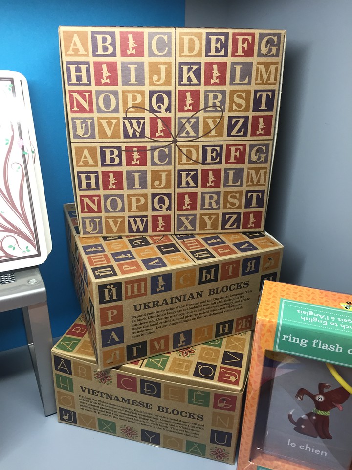 Uncle Goose Classic ABC blocks displayed in store on shelf in Ukranian, Vietnamese, and English