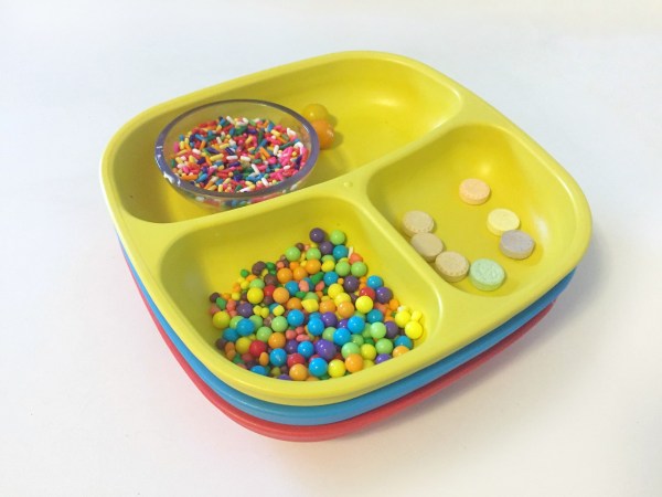 Re-Play pack of 3 plates stacked with gingerbread house candy decorations inside