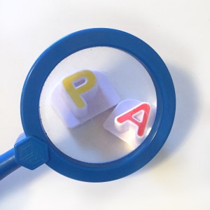 Blue kids magnifying glass enlarging yellow P and red A letters