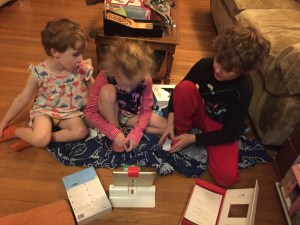 Three kids gathered around Osmo Coding with Awbie on the floor