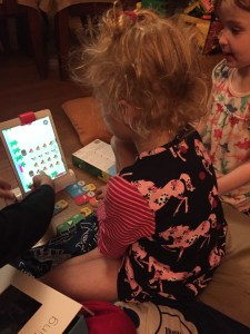 Kids playing Osmo Coding Awbie on living room floor
