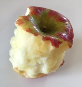 Half eaten red apple turning slightly brown